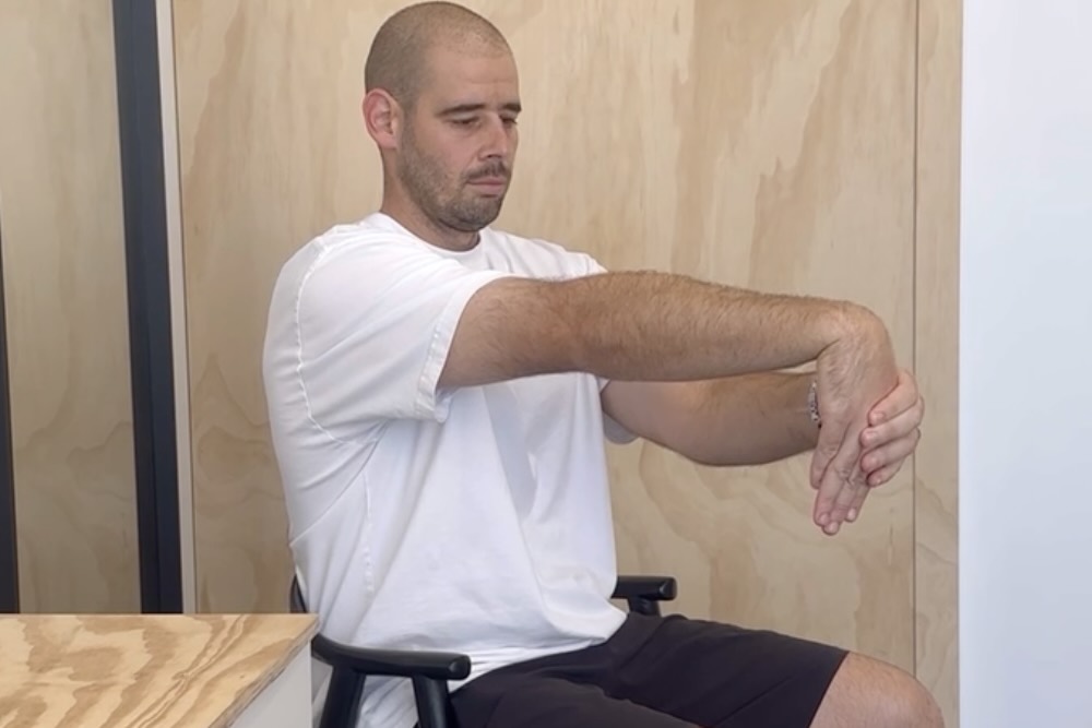 James doing a wrist extensor stretch to demonstrate the best exercises for tennis elbow